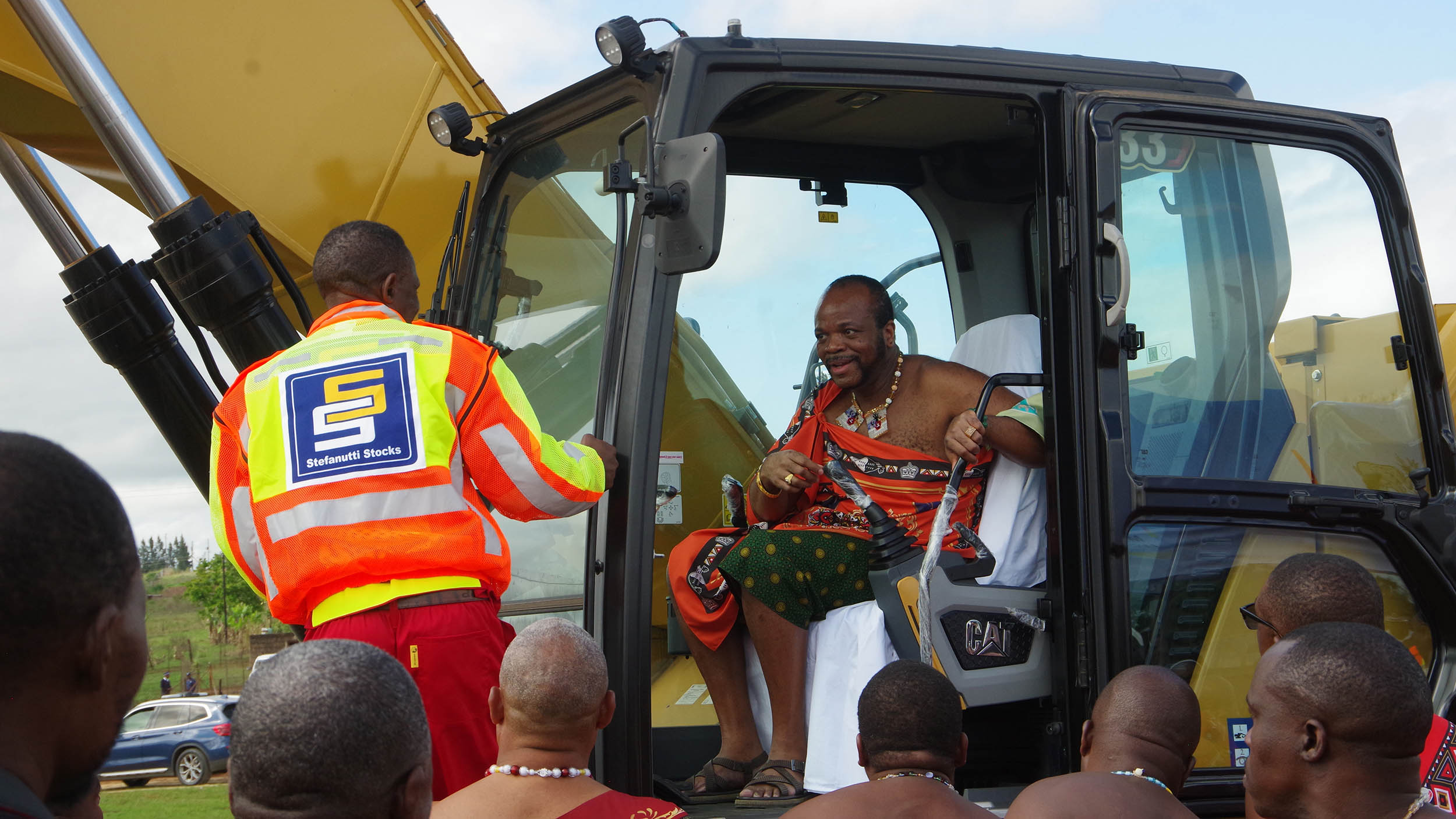 His Majesty King Mswati III appreciating Sive Mamba after coaching him on how to operate the excavator.